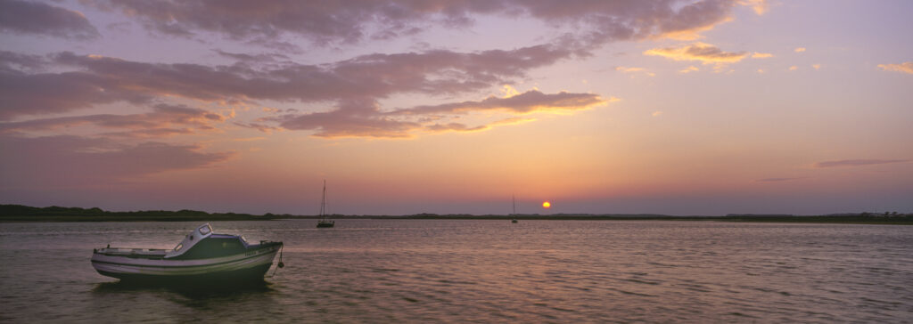 England, Cumbria, Lake District National Park. A colourful sunset over the coast near the coastal town of Ravenglass, the only part of coast within the lake district national park.