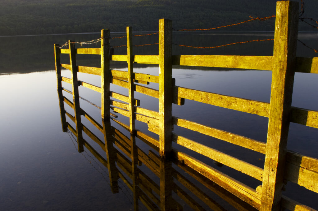 England, Cumbria, Lake District National Park. Dawn looking across the still waters of Coniston Water, within the Lake District National Park.