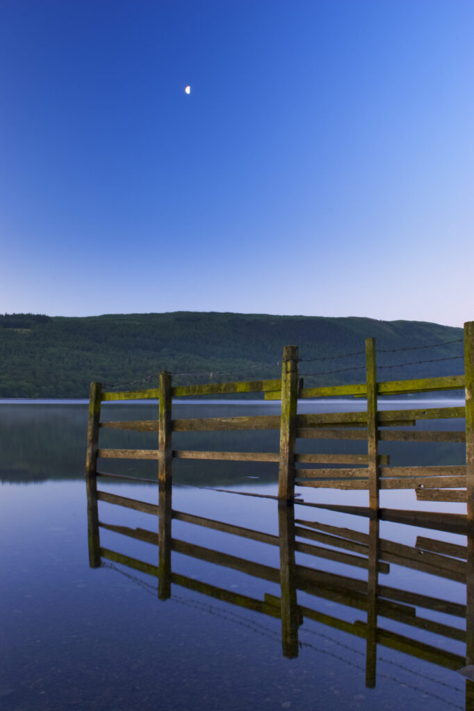England, Cumbria, Lake District National Park. Dawn looking across the still waters of Coniston Water, within the Lake District National Park.