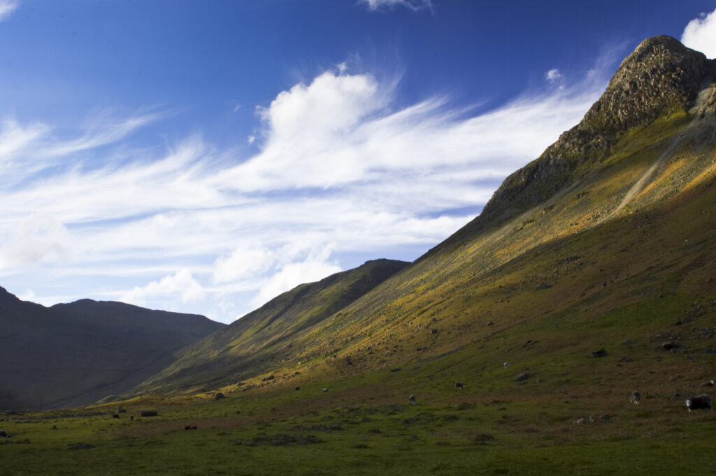 England, Cumbria, Lake District National Park. A fleeting shaft of light highlights the features of the Langdale mountains.