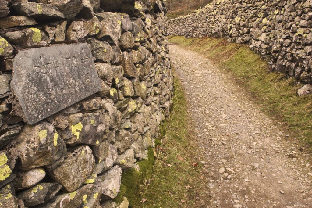 England, Cumbria, Lake District National Park. Public footpath running between dry stone walls near Stonethwaite in Borrowdale.