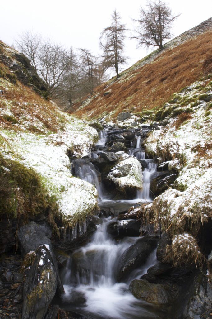 England, Cumbria, Lake District National Park. Whit Beck, surrounded by a light dusting of winter snow.