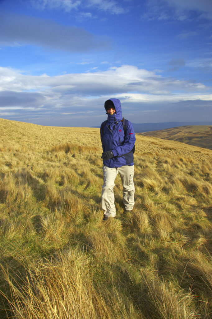 England, Northumberland, Northumberland National Park. Female hiker walking from Snear Hill in the Harthope Valley.
