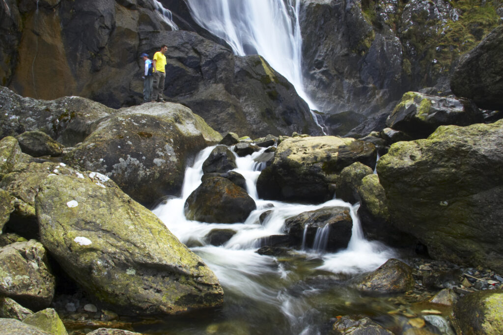 Wales, Caernarfonshire, Snowdonia National Park. Tourists admiring the dramatic Aber Falls, within the Coedydd Aber National Nature Reserve.