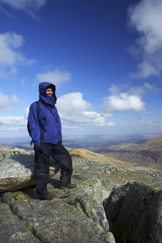 Wales, Caernarfonshire, Snowdonia National Park. Female hiker admiring the view from the summit of the Glyder Fach mountain.