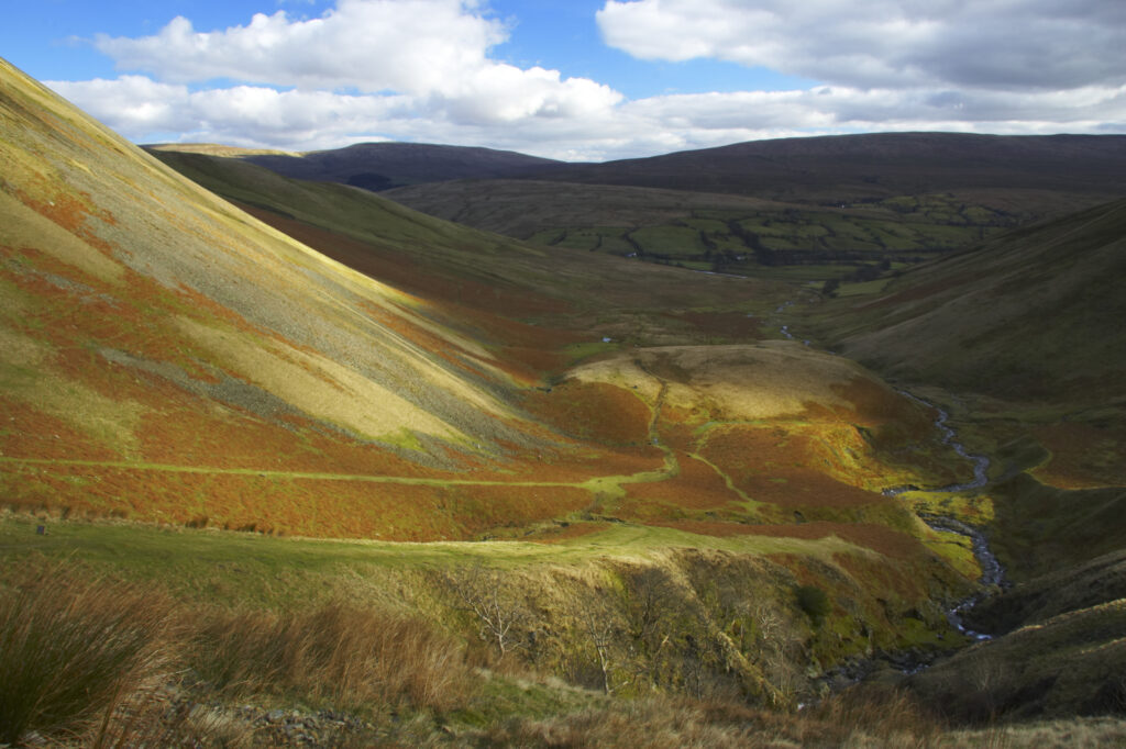 England, Cumbria, Yorkshire Dales National Park. A shaft of light illuminates the hills of the park, located to the north east of the town of Sedbergh. Viewed from the Howgills.