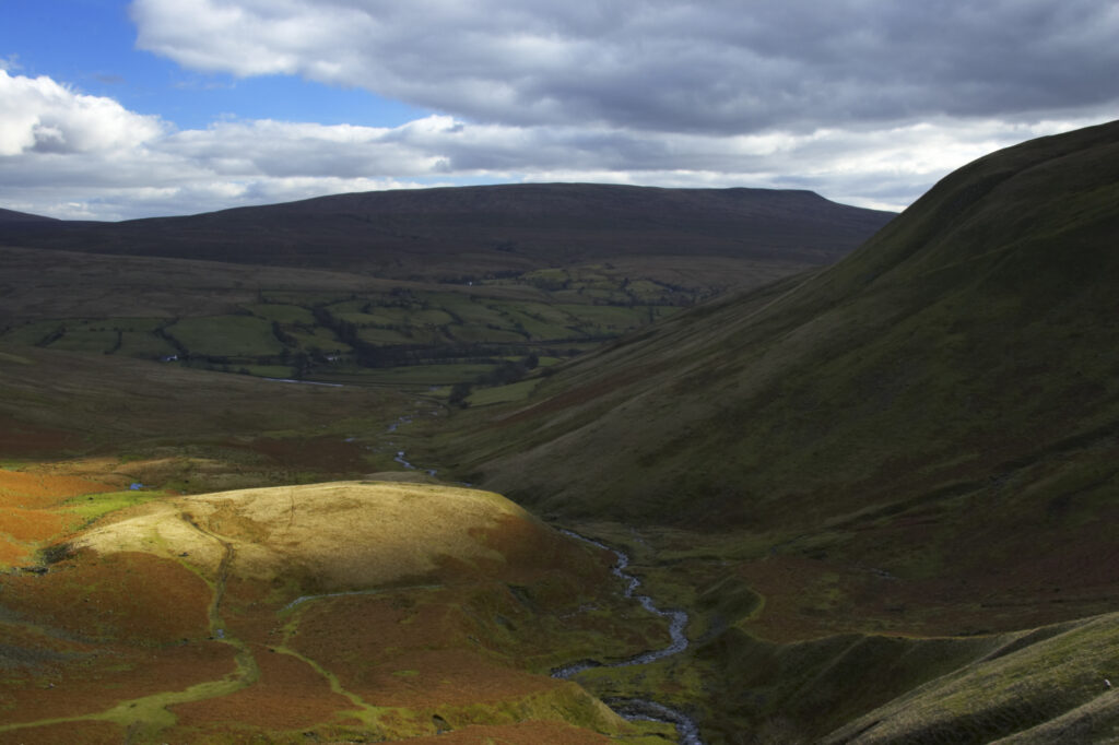 England, Cumbria, Yorkshire Dales National Park. A shaft of light illuminates the hills of the park, located to the north east of the town of Sedbergh. Viewed from the Howgills.