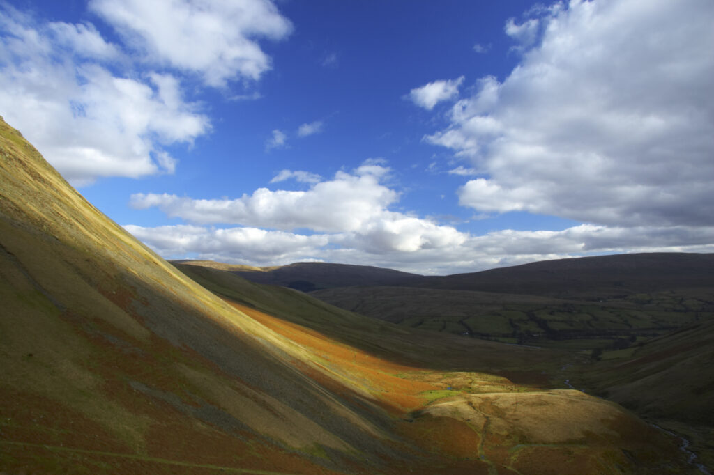 England, Cumbria, Yorkshire Dales National Park. A shaft of light illuminates the hills of the park, located to the north east of the town of Sedbergh. Viewed from the Howgills.