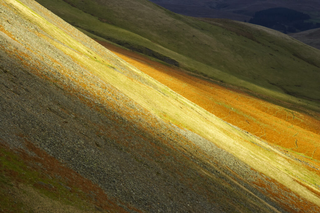 England, Cumbria, Yorkshire Dales National Park. A shaft of light illuminates the hills of the park, located to the north east of the town of Sedbergh. Viewed from the Howgills.