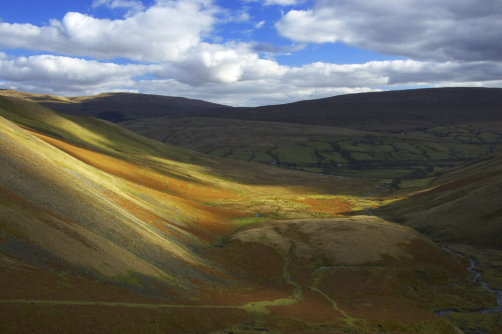 England, Cumbria, Yorkshire Dales National Park. A shaft of light illuminates the hills of the park, located to the north east of the town of Sedbergh. Viewed from the Howgills.
