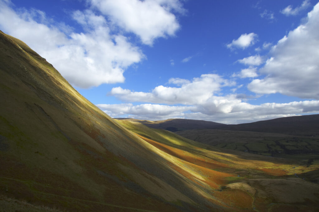 England, Cumbria, Yorkshire Dales National Park. A shaft of light illuminates the hills of the park, located to the north east of the town of Sedbergh. Viewed from the Howgills.
