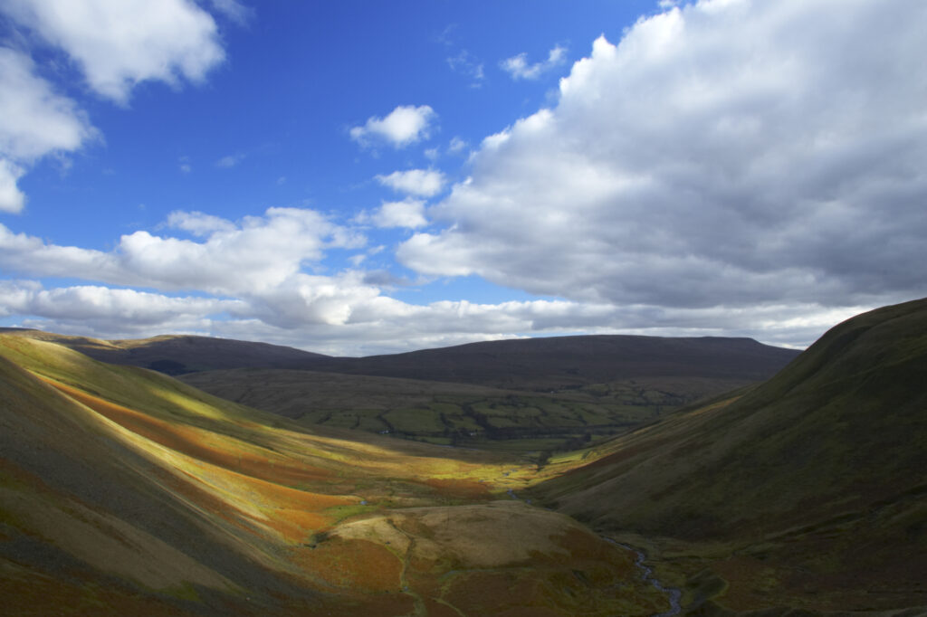 England, Cumbria, Yorkshire Dales National Park. A shaft of light illuminates the hills of the park, located to the north east of the town of Sedbergh. Viewed from the Howgills.