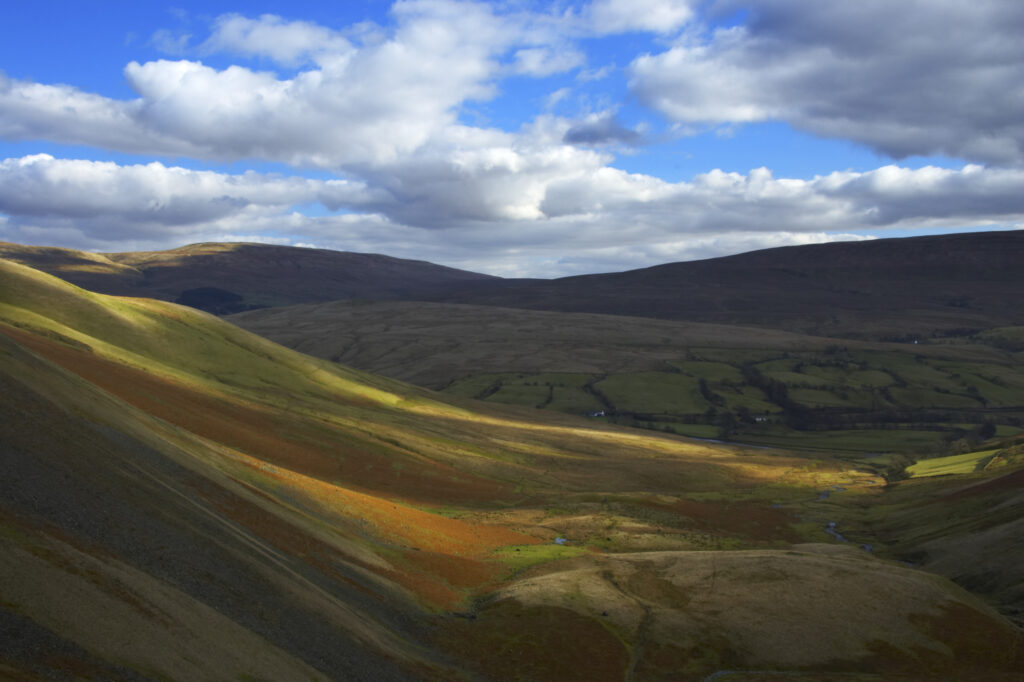 England, Cumbria, Yorkshire Dales National Park. A shaft of light illuminates the hills of the park, located to the north east of the town of Sedbergh. Viewed from the Howgills.