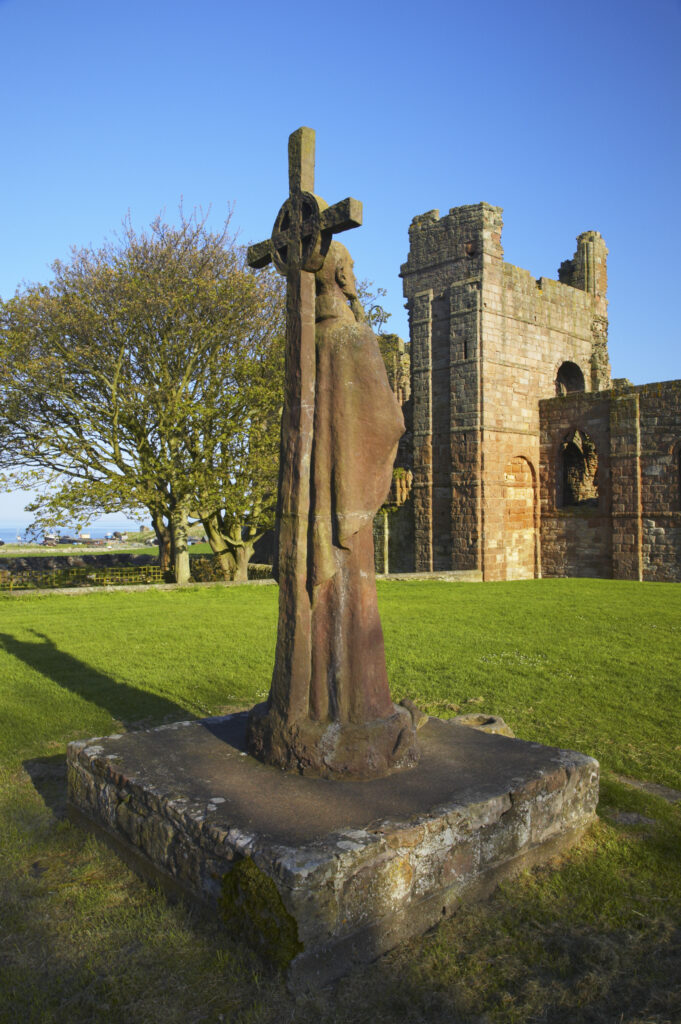 England, Northumberland, Lindisfarne / Holy Island. Statue of St. Aidan in the grounds of the Lindisfarne Priory, located upon Holy Island along the Northumberland Heritage Coast.