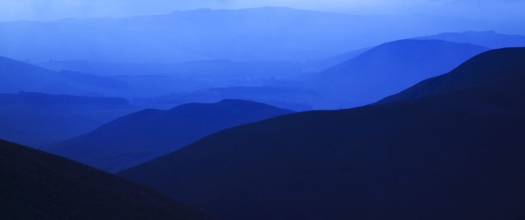 Scotland, Scottish Borders, The Pennine Way. Mist shrouds the rolling hills of the Scottish Uplands, viewed from the low level route of the Pennine Way near Kirk Yetholm.