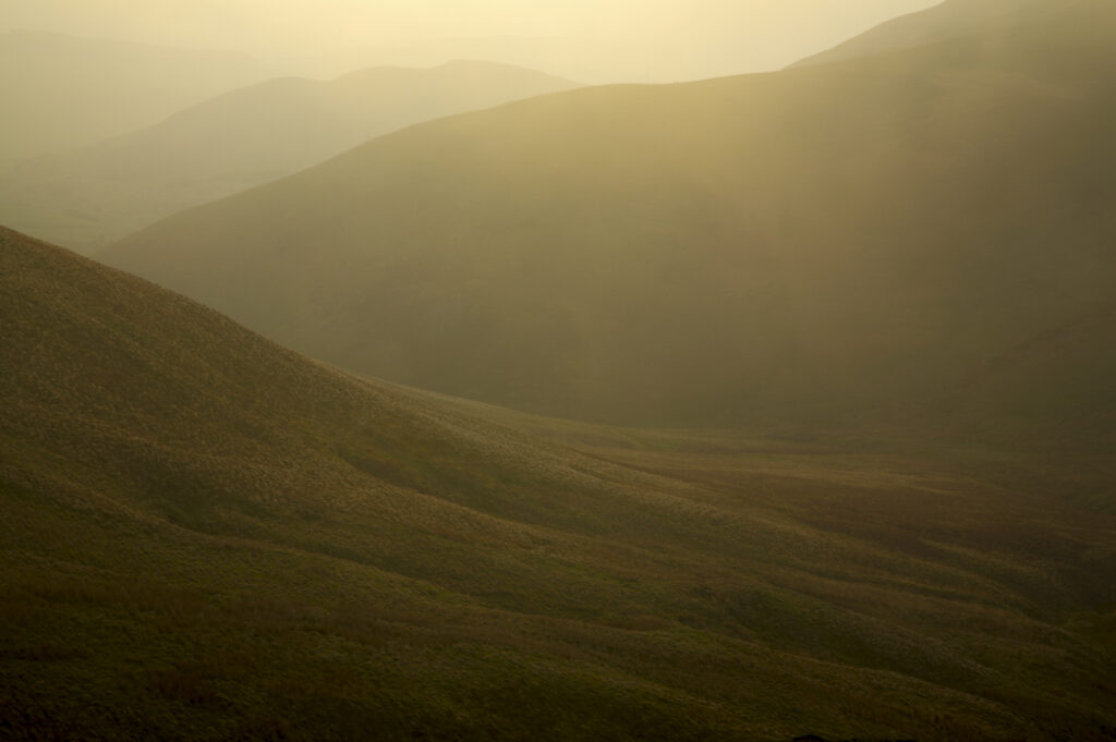 Scotland, Scottish Borders, The Pennine Way. Mist begins to shroud the rolling hills of the Scottish Uplands, viewed from the low level route of the Pennine Way near Kirk Yetholm.