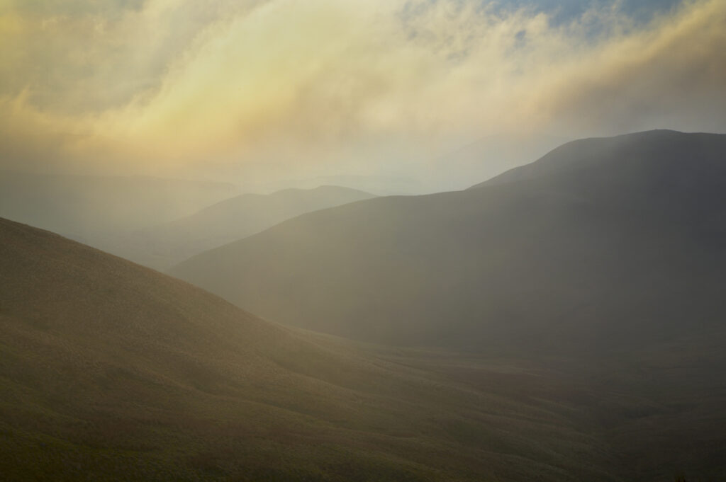Scotland, Scottish Borders, The Pennine Way. Mist begins to shroud the rolling hills of the Scottish Uplands, viewed from the low level route of the Pennine Way near Kirk Yetholm.