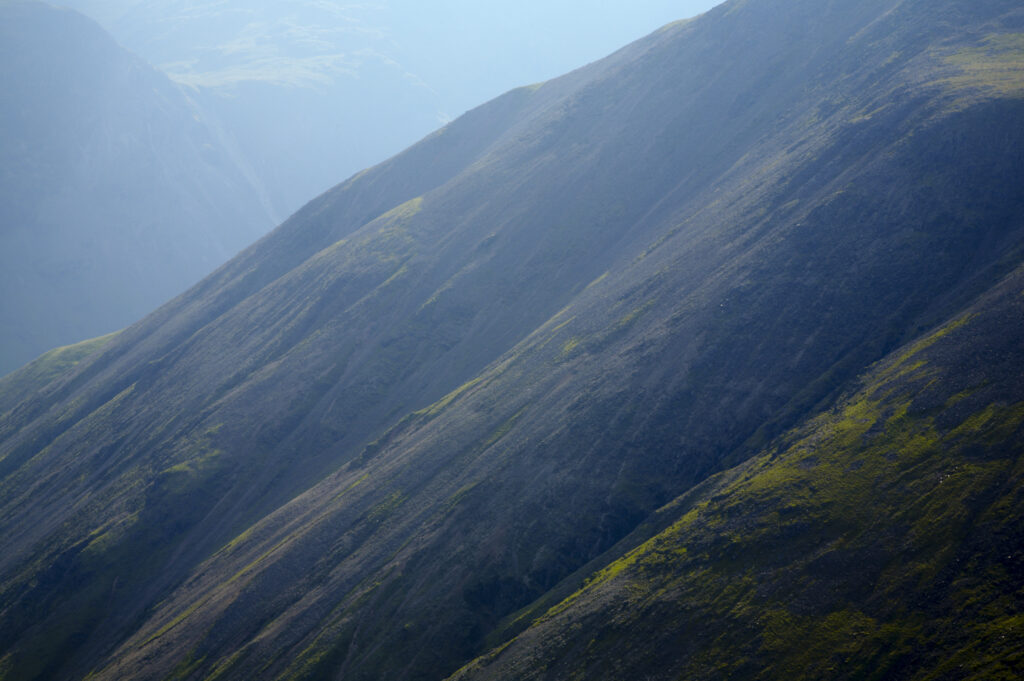 England, Cumbria, Lake District National Park. Mist surrounds a mountain side viewed from Great Gable in the Western Lakes