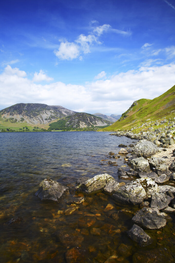 England, Cumbria, Lake District National Park The rocky lake shore of Ennerdale Water in the western region of the Lake District