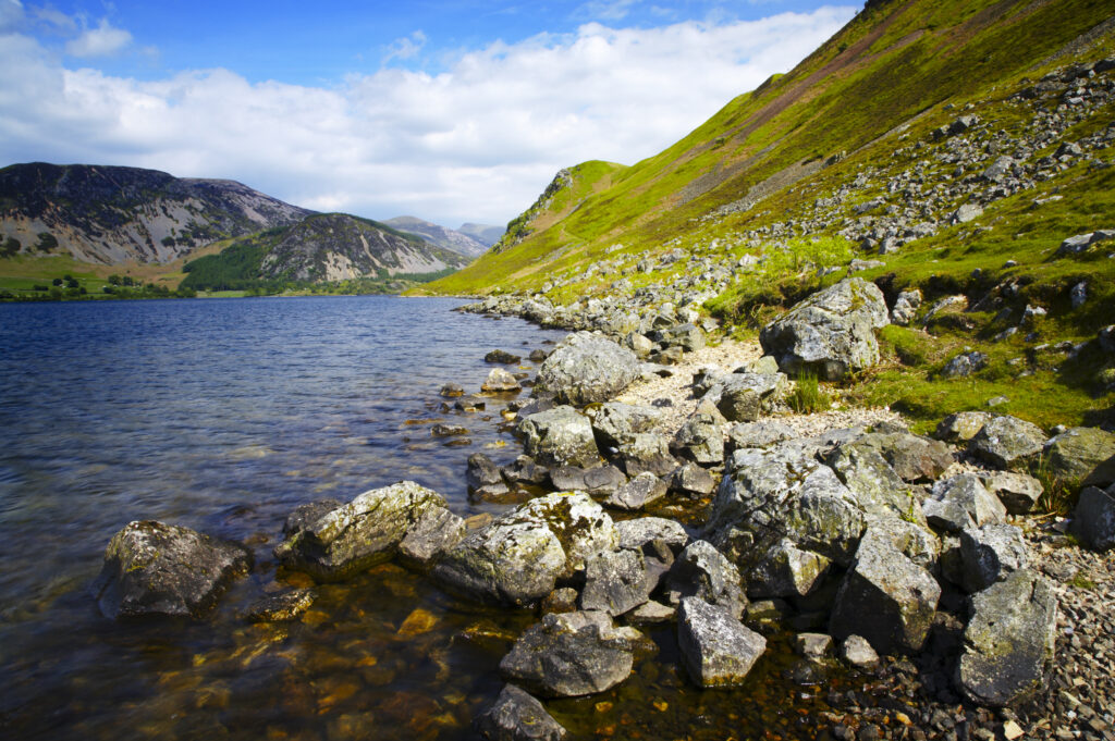 England, Cumbria, Lake District National Park The rocky lake shore of Ennerdale Water in the western region of the Lake District
