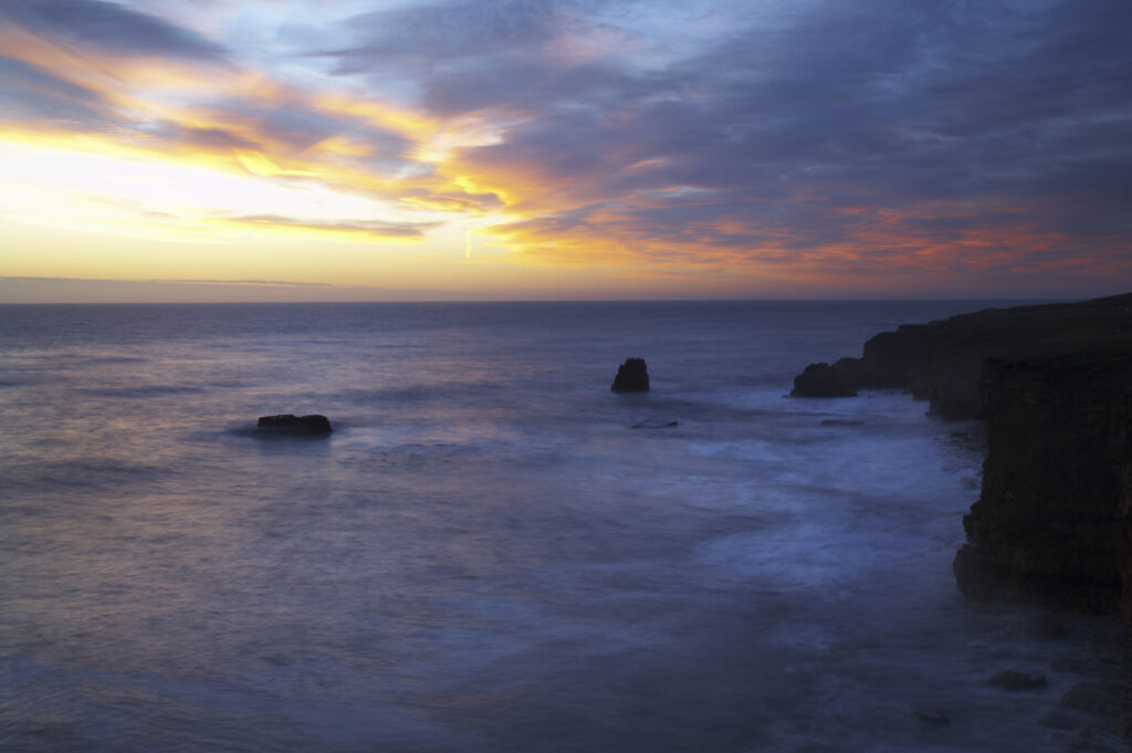 England, Tyne and Wear, Marsden Bay. Sunrise over the North Sea, near Lizard Point and Marsden Bay.