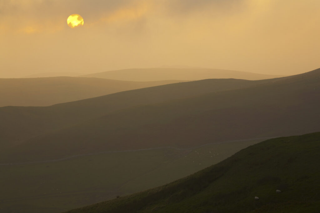 England, Northumberland, Northumberland National Park. Sunset over the rolling Cheviot Hills, viewed from the Border Coutry Ride route near Murder Cleugh.