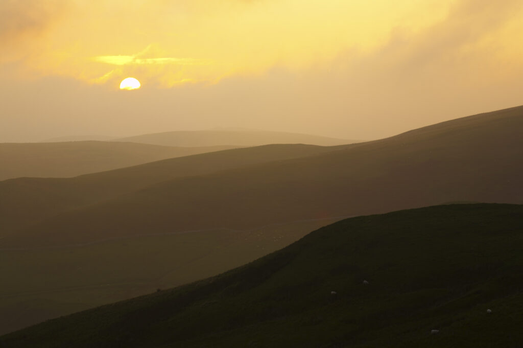 England, Northumberland, Northumberland National Park. Sunset over the rolling Cheviot Hills, viewed from the Border Coutry Ride route near Murder Cleugh.