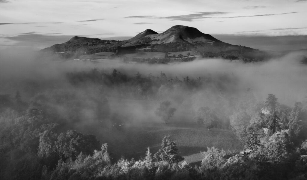 Scotland, Scottish Borders, Melrose. Autumn mists rise from the low lying countryside surrounding the The Eildon Hills, viewed from the famous viewpoint of Scott's View near Newton St Boswells.