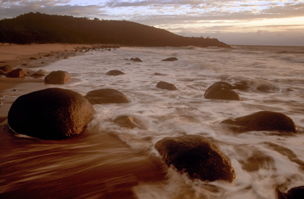 AUSTRALIA, Queensland, Hinchinbrook Island National Park. Soft morning light bathes the coastline of the Little Ramsey Bay
