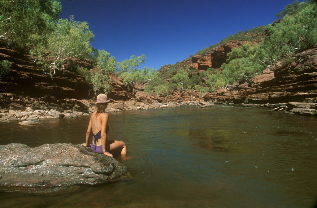AUSTRALIA, Western Australia, Kalbarri National Park. Girl relaxing in the flowing waters of the Z Bend Gorge