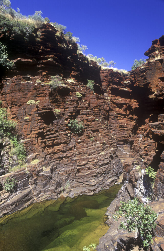 AUSTRALIA, Western Australia, Karajini National Park. The vibrant red colour of the Joffre Gorge, contrasting against a blue outback sky.