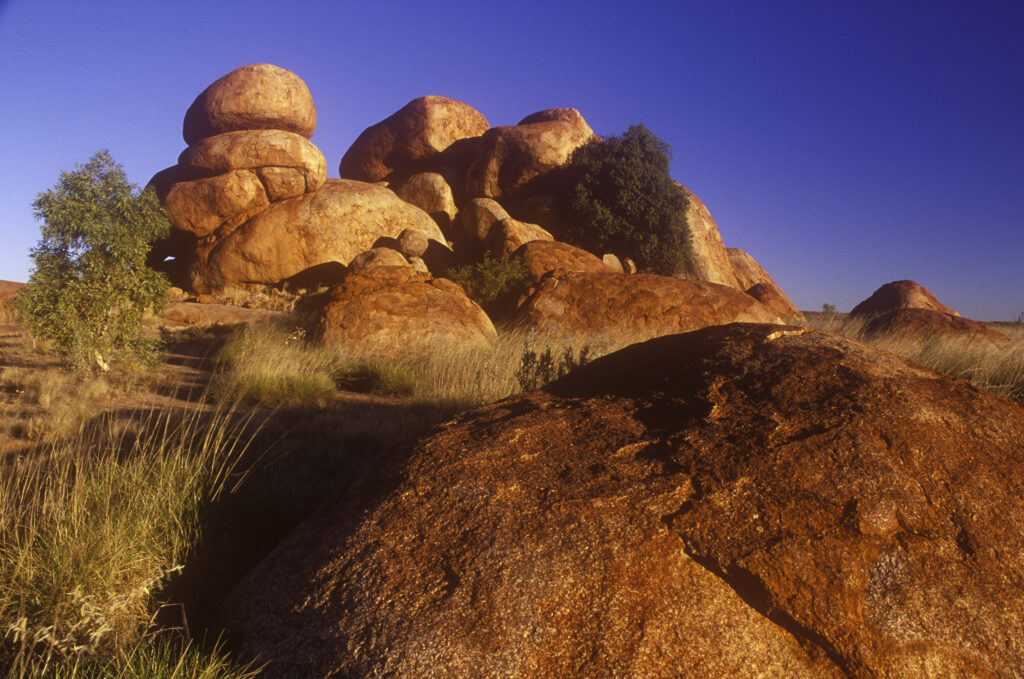 AUSTRALIA, Northern Territory, Devils Marbles. Evening light illuminates the boulders of this popular tourist destination