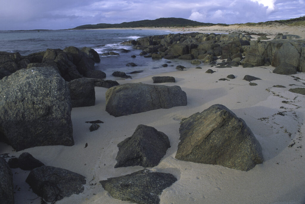AUSTRALIA, Western Australia, Peaceful Bay. Soft light illuminates the rocks and white sands of this beach part of Walpole National Park.