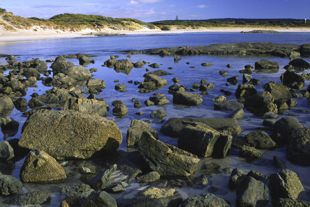 AUSTRALIA, Western Australia, Peaceful Bay. Soft light illuminates the rocks and white sands of this beach part of Walpole National Park.
