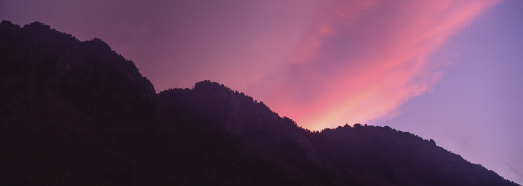 FRANCE, Midi Pyrenees, Pyrenees National Park. The setting sun iluminates clouds over the landscape surrounding the Lac de Gaub