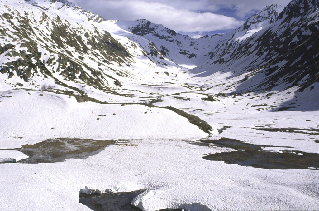 ITALY, Valle d'Aosta, Gran Paradiso National Park. Snow remains well into spring in the peaks of the mountain landscape of the western Alps and the valley near Bardoney.