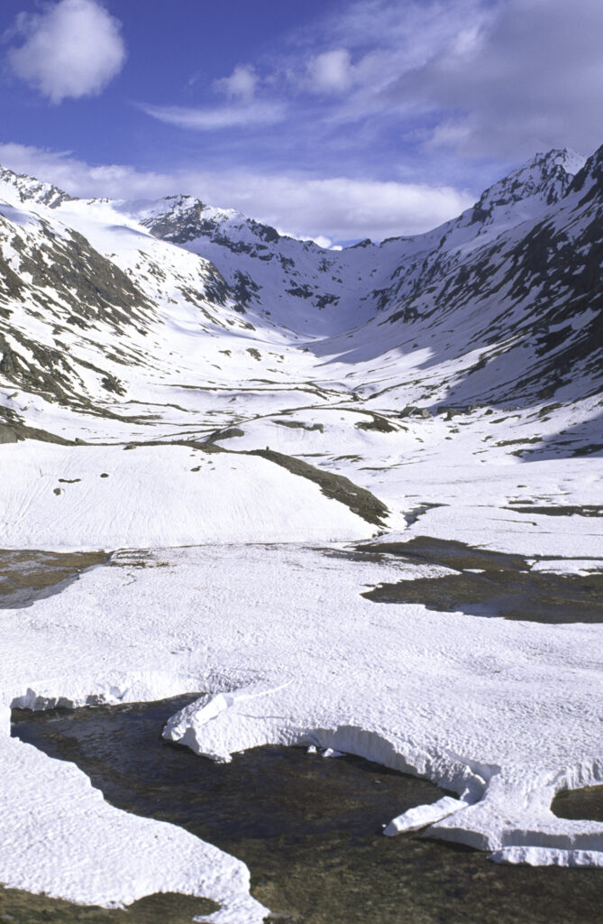 ITALY, Valle d'Aosta, Gran Paradiso National Park. Snow remains well into spring in the peaks of the mountain landscape of the western Alps and the valley near Bardoney.