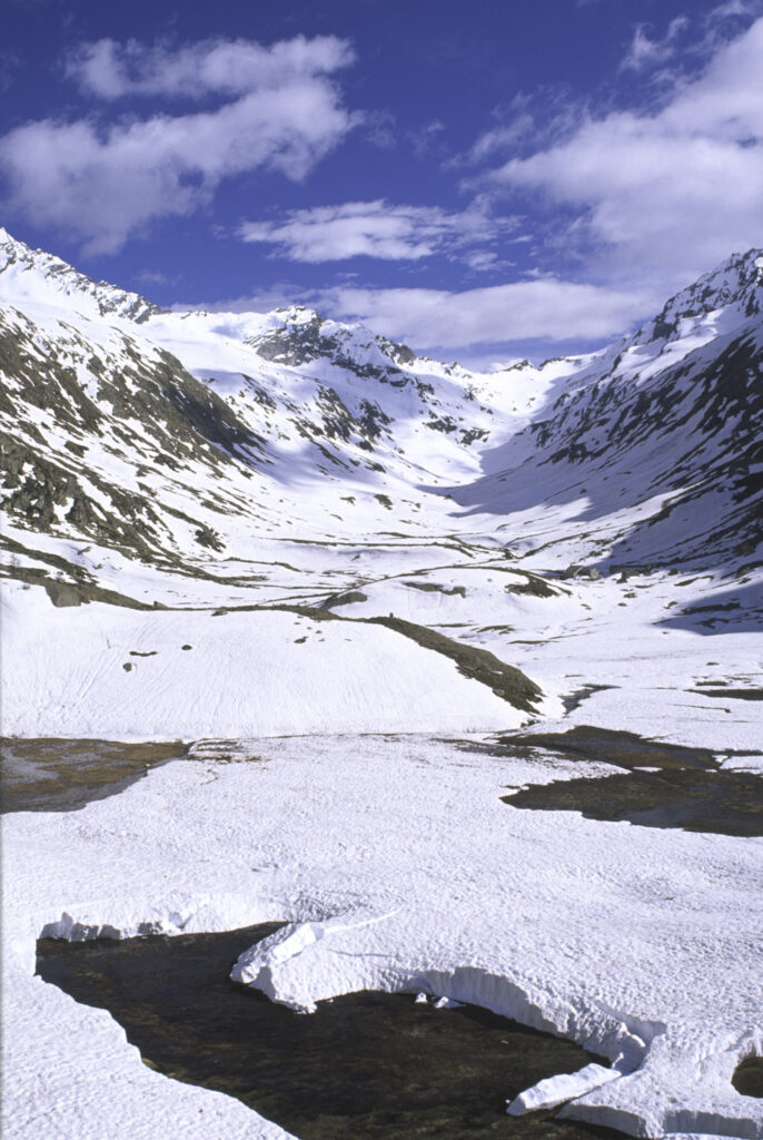 ITALY, Valle d'Aosta, Gran Paradiso National Park. Snow remains well into spring in the peaks of the mountain landscape of the western Alps and the valley near Bardoney.