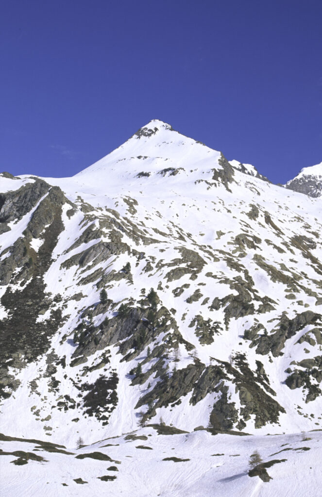 ITALY, Valle d'Aosta, Gran Paradiso National Park. Snow remains well into spring in the peaks of the mountain landscape of the western Alps and the valley near Bardoney.