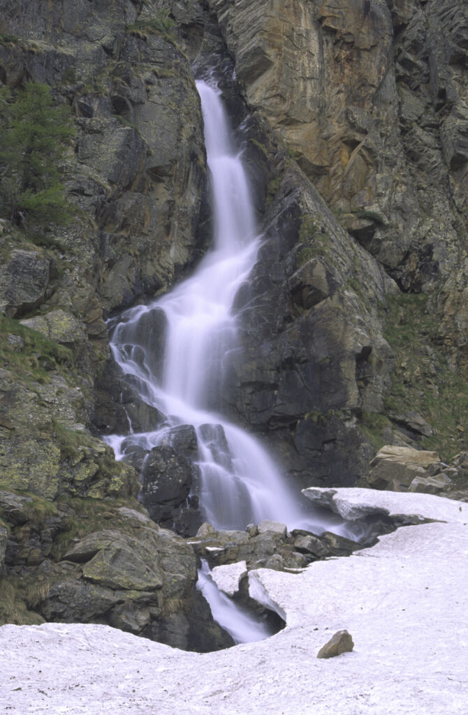ITALY, Valle d'Aosta, Gran Paradiso National Park. A small waterfall revealed after the spring thaw of the western Alps in the Valnontey valley.
