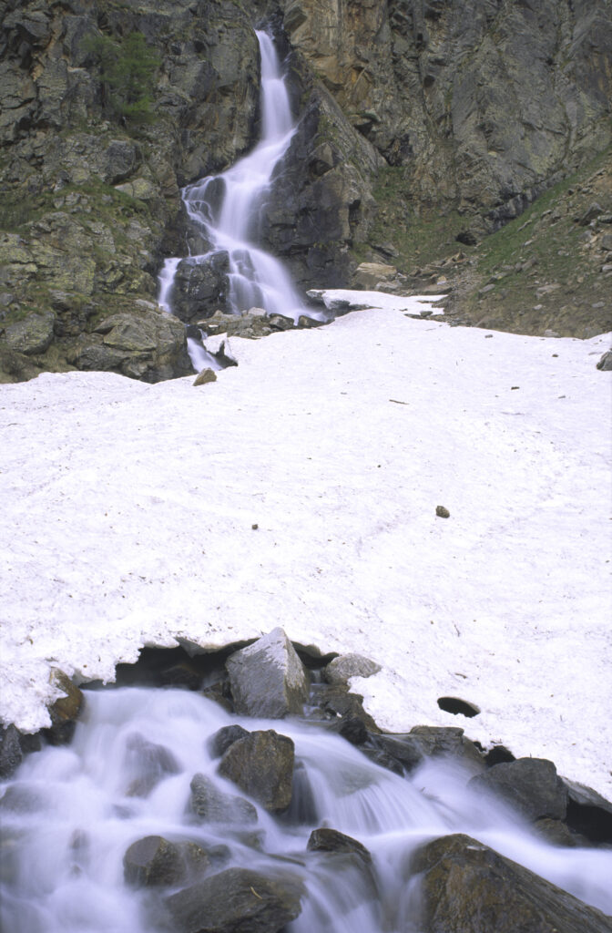 ITALY, Valle d'Aosta, Gran Paradiso National Park. A small waterfall revealed after the spring thaw of the western Alps in the Valnontey valley.