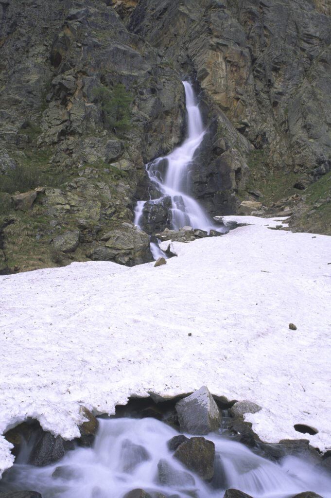 ITALY, Valle d'Aosta, Gran Paradiso National Park. A small waterfall revealed after the spring thaw of the western Alps in the Valnontey valley.