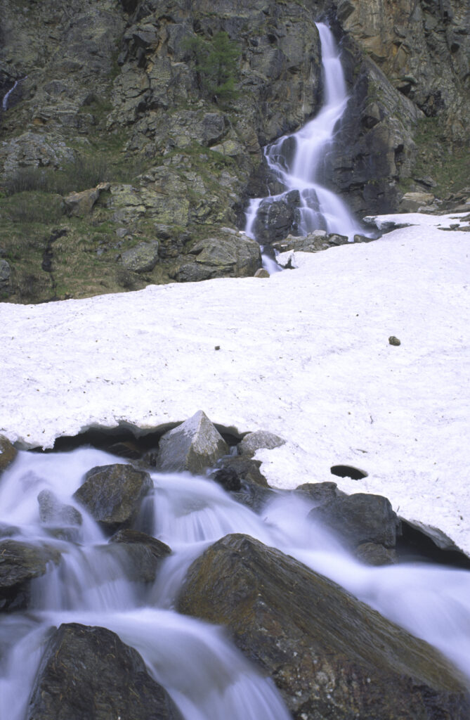 ITALY, Valle d'Aosta, Gran Paradiso National Park. A small waterfall revealed after the spring thaw of the western Alps in the Valnontey valley.