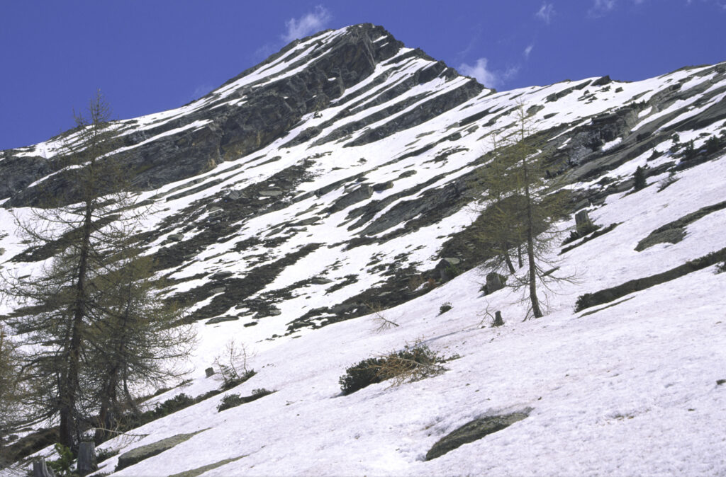 ITALY, Valle d'Aosta, Gran Paradiso National Park. Snow remains well into spring in the peaks of the mountain landscape of the western Alps above the Lillaz valley.