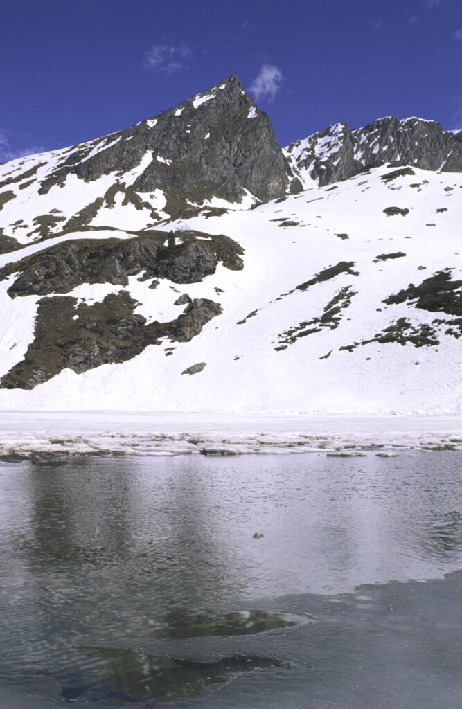 ITALY, Valle d'Aosta, Gran Paradiso National Park. The ice covered Lake Loie (lago di loie) in the peaks of the mountain landscape of the western Alps above the Lillaz valley.