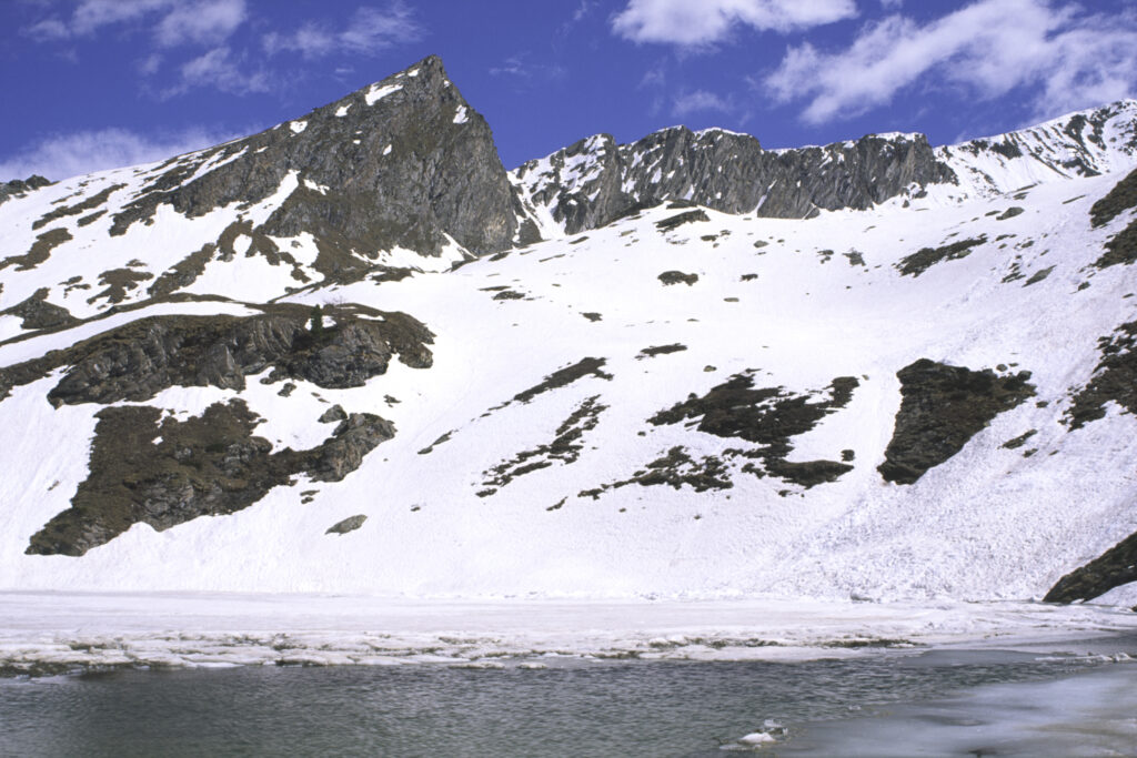 ITALY, Valle d'Aosta, Gran Paradiso National Park. The ice covered Lake Loie (lago di loie) in the peaks of the mountain landscape of the western Alps above the Lillaz valley.