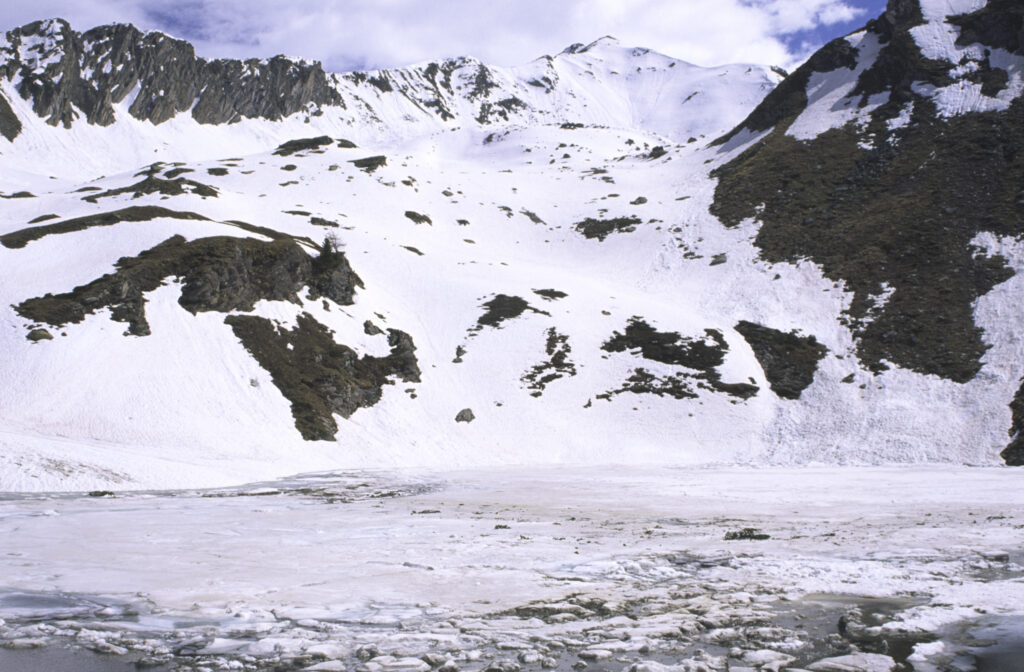 ITALY, Valle d'Aosta, Gran Paradiso National Park. The ice covered Lake Loie (lago di loie) in the peaks of the mountain landscape of the western Alps above the Lillaz valley.