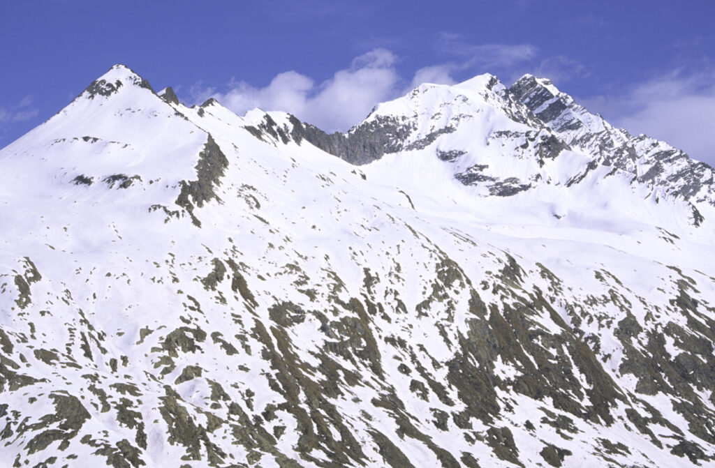 ITALY, Valle d'Aosta, Gran Paradiso National Park. Snow remains well into spring in the peaks of the mountain landscape of the western Alps and the valley near Bardoney.