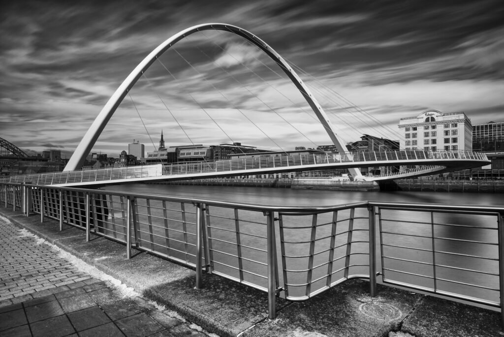 England, Tyne and Wear, Gateshead. The Gateshead Millenium Bridge on the Gateshead Quayside, with the Newcastle Upon Tyne Quayside in the distance.