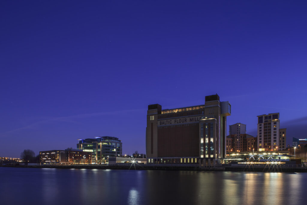 England, Tyne and Wear, Gateshead. The Baltic Gallery in Gateshead viewed at dusk from across the River Tyne.